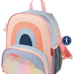 May include: A pink, blue, and orange rainbow-shaped backpack with a iridescent cloud pocket and a mesh side pocket. The backpack has a pink zipper and a Skip Hop logo.