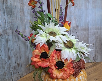 Fall sunflower table arrangement in orange ceramic pumpkin vase, table centerpiece with orange and white sunflowers with brown cattails