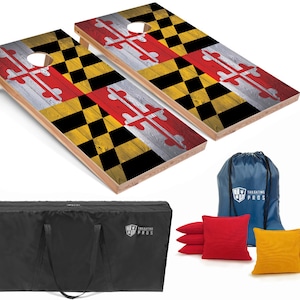 May include: Two wooden cornhole boards with a Maryland flag design. The boards are set up for a game, with the bags in the background. The bags are red, yellow, and blue. The boards are made of wood and have a distressed look. The boards are also decorated with the words "Tailgating Pros".