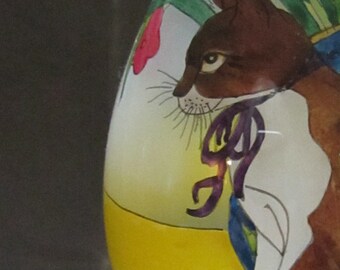 Inside Painted Decorative Glass Egg with Sitting Cat and Vase of Flowers on wood stand