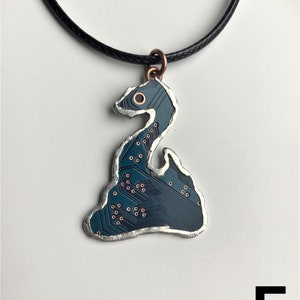 May include: A dark blue circuit board pendant shaped like a snake, with copper accents, hanging from a black cord.