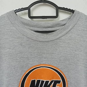 May include: A white ceramic mug with a black handle and the text "But First, Coffee" in a handwritten style. The mug is on a white surface. The mug is 4 inches tall.