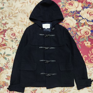 May include: A navy blue hooded duffle coat with toggle closures and two front pockets. The coat features a hood and is made of a thick, warm material. The brand name "BEAUTY&YOUTH" is visible on a tag inside the coat.