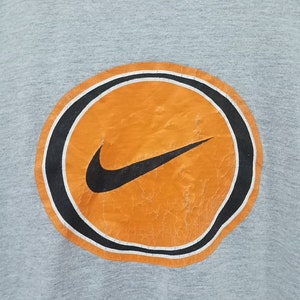 May include: A set of three ceramic mugs with a speckled, matte finish. The mugs are in shades of cream, light gray, and dark gray. Each mug has a simple, minimalist design and a rounded handle. The mugs are likely for coffee or tea.