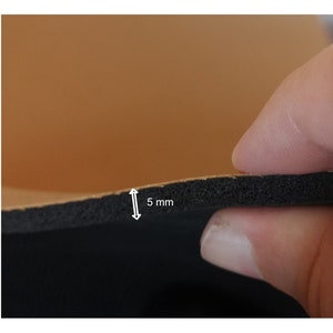 Op de afbeelding: Close-up van een bruin lederen materiaal met een zwarte schuimrug. Het schuim is 5 mm dik.