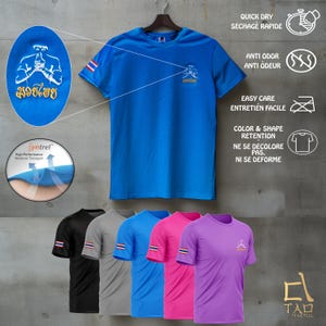 Puede incluir: Una camiseta deportiva azul con un peque&ntilde;o logotipo y texto tailand&eacute;s. La camiseta tiene cuello redondo y mangas cortas. Se muestran camisetas adicionales en negro, gris, azul, rosa y morado debajo. La camiseta es de secado r&aacute;pido y resistente al olor.