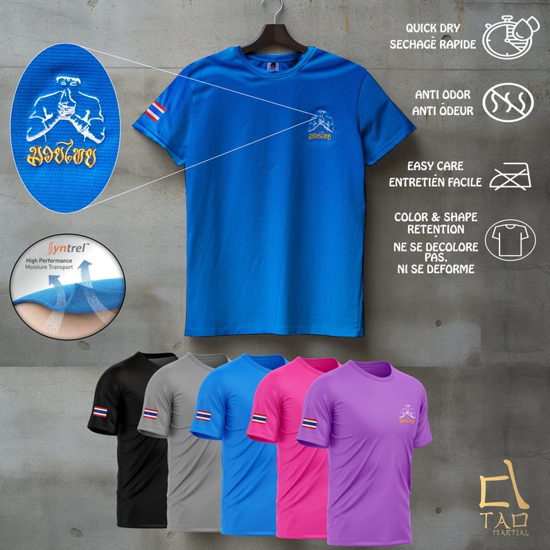 Puede incluir: Una camiseta deportiva azul con un peque&ntilde;o logotipo y texto tailand&eacute;s. La camiseta tiene cuello redondo y mangas cortas. Se muestran camisetas adicionales en negro, gris, azul, rosa y morado debajo. La camiseta es de secado r&aacute;pido y resistente al olor.