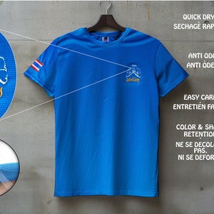 Puede incluir: Camiseta deportiva azul con mangas cortas, con bordados en escritura tailandesa y un gr&aacute;fico de un artista marcial. La camiseta incluye la bandera tailandesa en la manga y est&aacute; dise&ntilde;ada para un secado r&aacute;pido y f&aacute;cil cuidado.