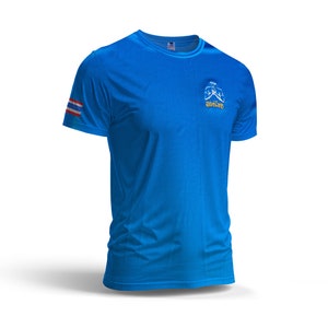 Puede incluir: Una camiseta deportiva azul brillante con cuello redondo y mangas cortas. La camiseta presenta un peque&ntilde;o gr&aacute;fico en el pecho y un dise&ntilde;o de rayas en la manga izquierda. La tela tiene un sutil patr&oacute;n texturizado.