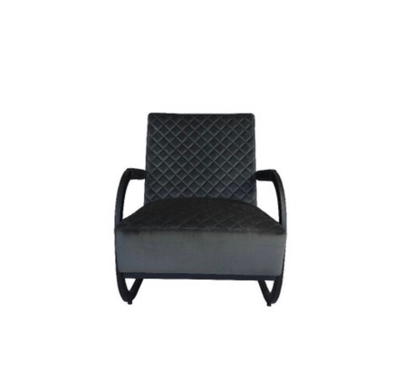 Puede incluir: Un sill&oacute;n acolchado negro con brazos y patas de madera curvados. El sill&oacute;n tiene un patr&oacute;n de diamante en la tapicer&iacute;a.