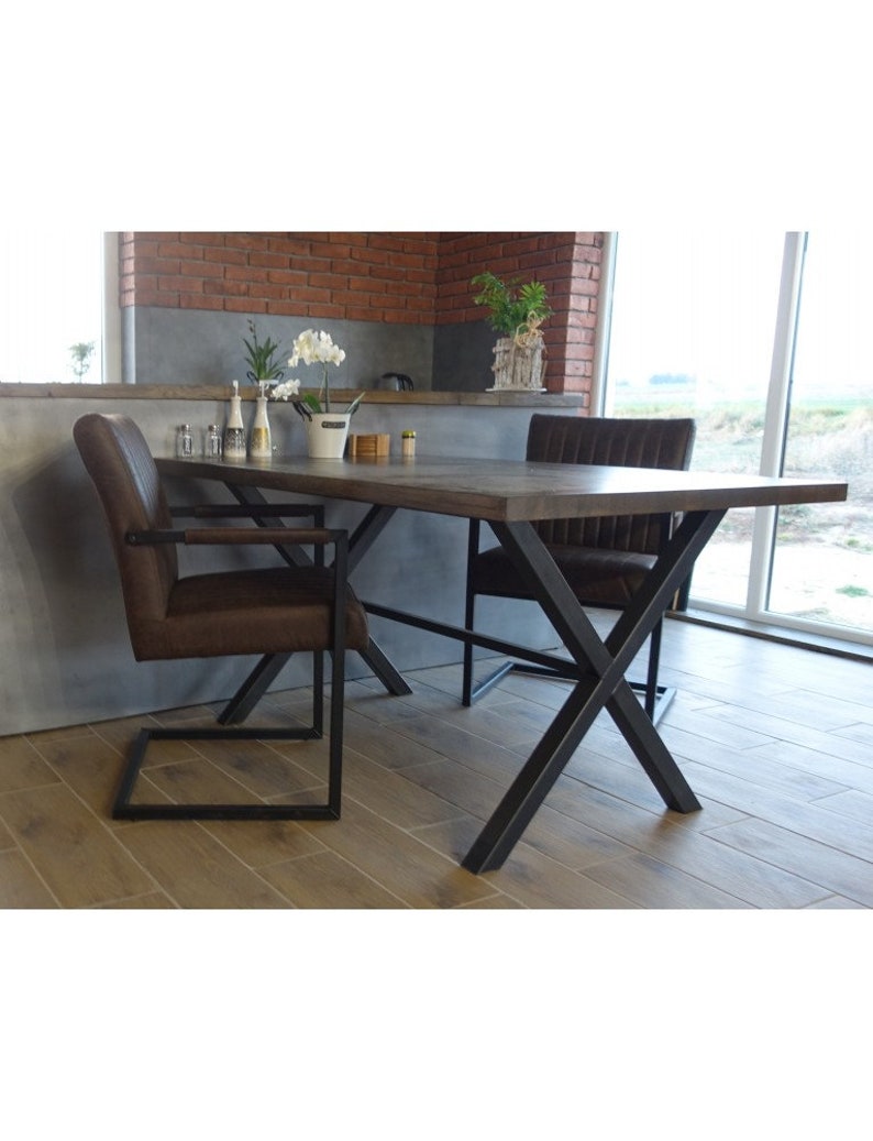 May include: A brown leather dining chair with a black metal frame and a wooden table with a black metal X-shaped base.