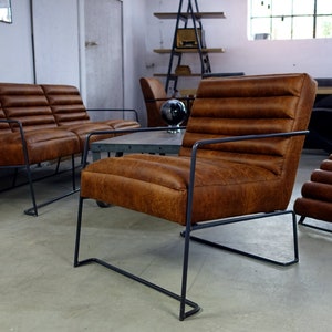 May include: A set of brown leather chairs with black metal frames. The chairs have a tufted design and are arranged in a living room setting.