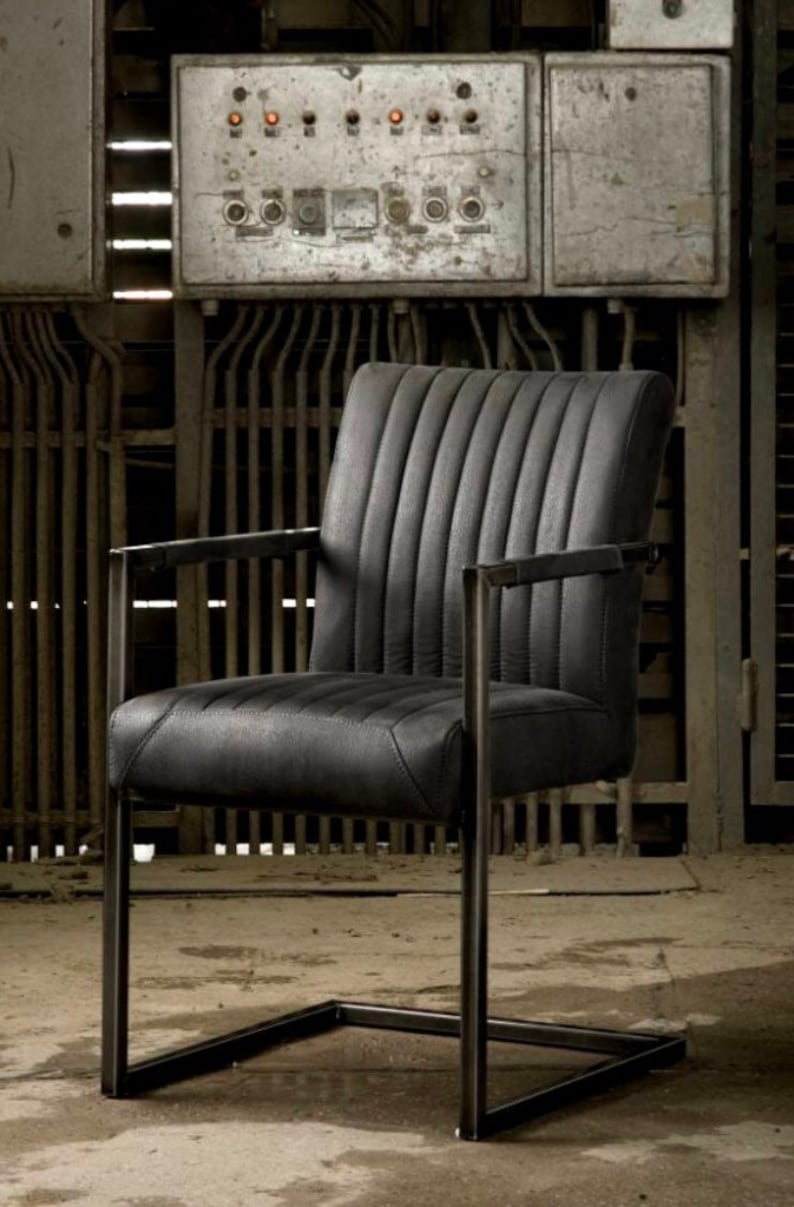 May include: A black leather chair with a metal frame. The chair has a tufted back and a square base.