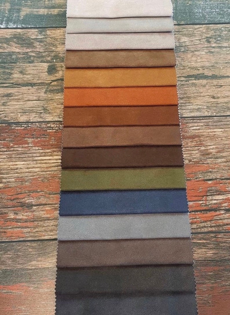 Puede incluir: Un muestrario de 15 muestras de tela en varios colores, incluyendo beige, marr&oacute;n, naranja, verde, azul y gris. Las muestras de tela est&aacute;n dispuestas en una fila vertical sobre un fondo de madera.