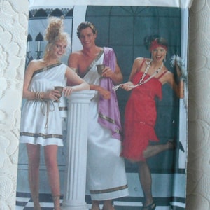 May include: Butterick 4199 sewing pattern featuring three people in Roman-style costumes. The cover shows a woman in a white dress, a man in a toga, and a woman in a red dress. The pattern includes all sizes.