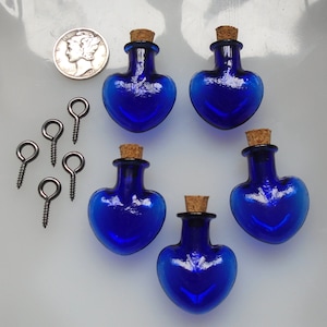 May include: Five cobalt blue glass heart-shaped bottles with cork stoppers and five silver eyelet screws.