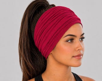 Könnte beinhalten: Ein weiches, tiefrotes Stirnband. Das breite Stirnband bedeckt die Stirn und hat eine geraffte Textur. Das Model trägt ein schwarzes Tanktop und hat die Haare zu einem Pferdeschwanz gebunden.