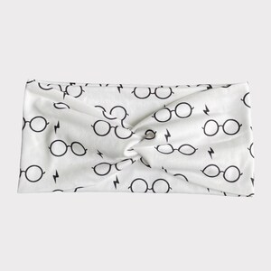 May include: White headband with a black repeating pattern of glasses and lightning bolts.