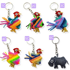 May include: Six colorful beaded keychains featuring rooster and rhino designs. The keychains are made with small, colorful beads and have a silver metal ring.