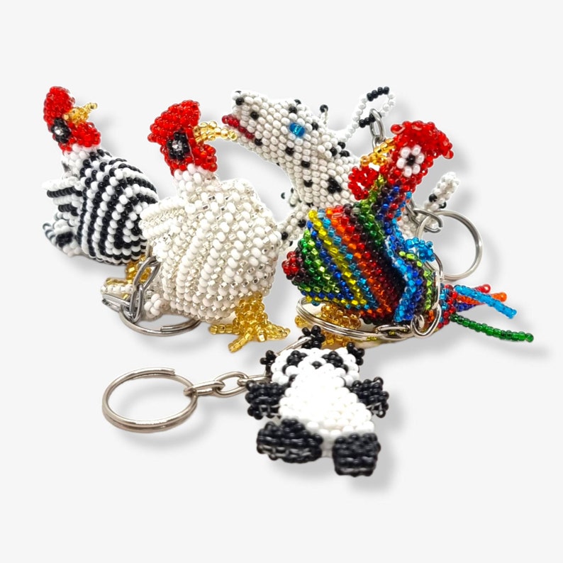 May include: A set of five beaded keychains featuring a variety of animal designs, including a zebra, a rooster, a panda, a rooster, and a dalmatian. The keychains are made with colorful beads and are perfect for adding a touch of whimsy to your keys.