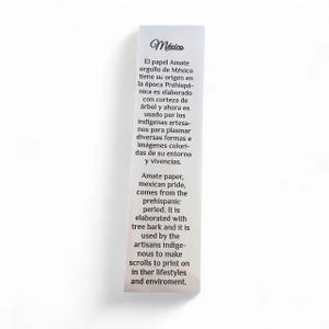 May include: A rectangular white card with text in Spanish and English. The text describes Amate paper, a Mexican product made from tree bark, used by indigenous artisans for colorful images and scrolls.