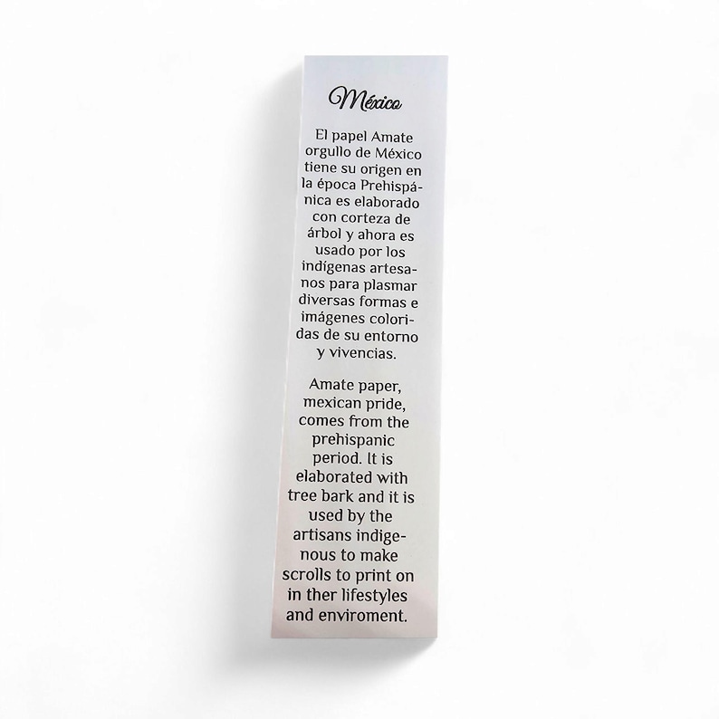 May include: A rectangular white card with text in Spanish and English. The text describes Amate paper, a Mexican product made from tree bark, used by indigenous artisans for colorful images and scrolls.