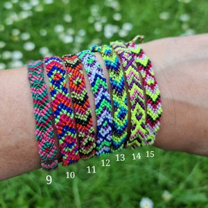 May include: A set of nine colorful friendship bracelets with geometric patterns. The bracelets are made with colorful embroidery floss and are numbered 9 through 15.