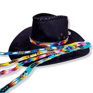 May include: A black cowboy hat with a beaded band and four colourful beaded straps. The straps are made of colourful beads and feature geometric patterns.