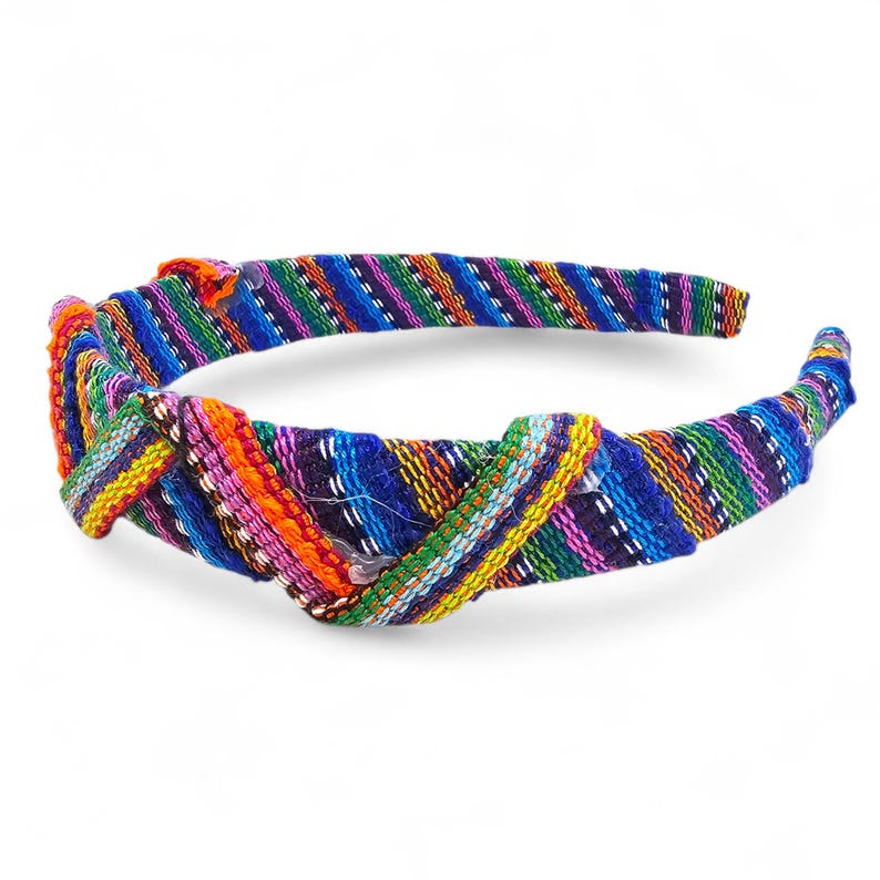 May include: A multi-coloured headband with a knotted design. The headband features a vibrant array of colours, including blue, green, purple, orange, and yellow, woven in a striped pattern. The accessory is designed to be worn on the head.