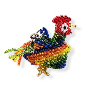 May include: A colorful beaded rooster keychain with red, orange, yellow, green, and blue beads. The rooster has a red comb and wattle, and a white eye.