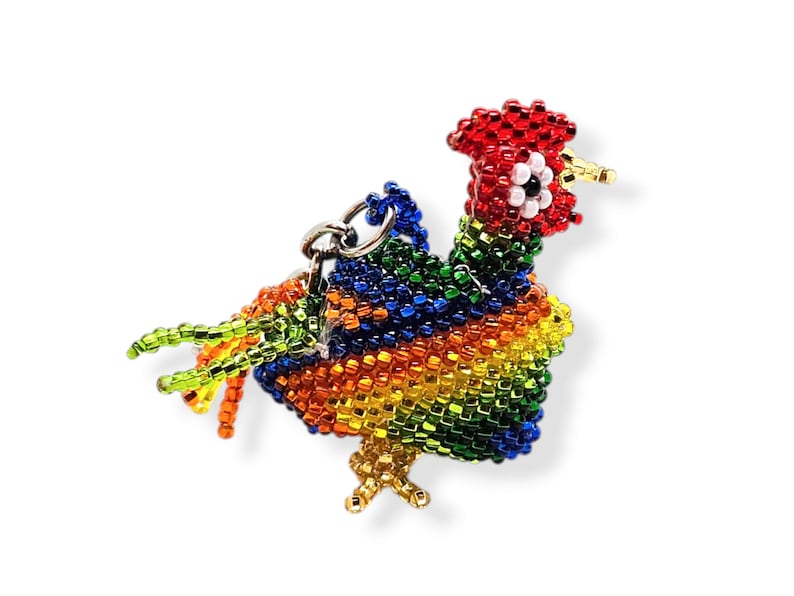 May include: A colorful beaded rooster keychain with red, orange, yellow, green, and blue beads. The rooster has a red comb and wattle, and a white eye.