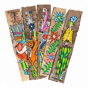 May include: Five hand-painted bookmarks with colorful floral and animal designs. Each bookmark features a unique illustration in vibrant hues of red, blue, yellow, and green on a textured brown background. The bookmarks are arranged in a fan shape.