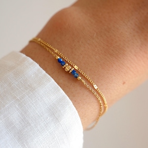 Verguld roestvrijstalen schakelarmband met blauwe kralen