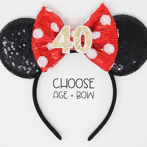 May include: Black and red sequined Minnie Mouse ears headband with a white and red polka dot bow and a gold number 40 on the bow. Choose age and bow.