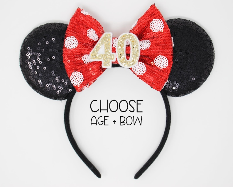 May include: Black and red sequined Minnie Mouse ears headband with a white and red polka dot bow and a gold number 40 on the bow. Choose age and bow.