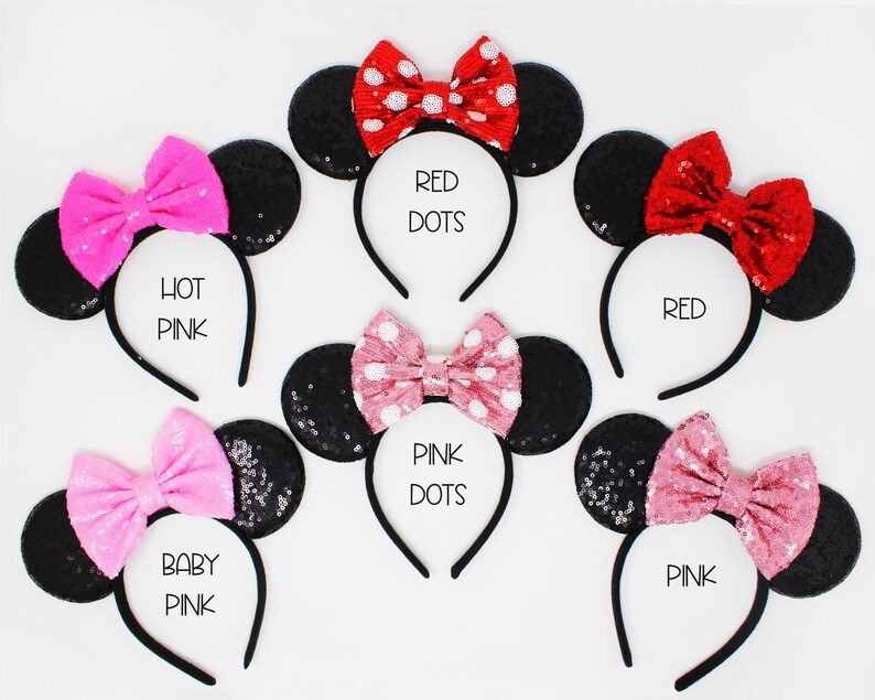 May include: Six black sequin mouse ear headbands with different colored bows. The bows are red with white polka dots, hot pink, pink with white polka dots, baby pink, red, and pink. The headbands are labeled with the bow colors.