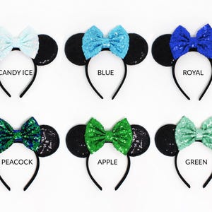 May include: Six headbands with black sequin ears and colorful sequin bows. The bows are labeled Candy Ice, Blue, Royal, Peacock, Apple, and Green. Each headband features a thin black band and two round ears covered in black sequins.