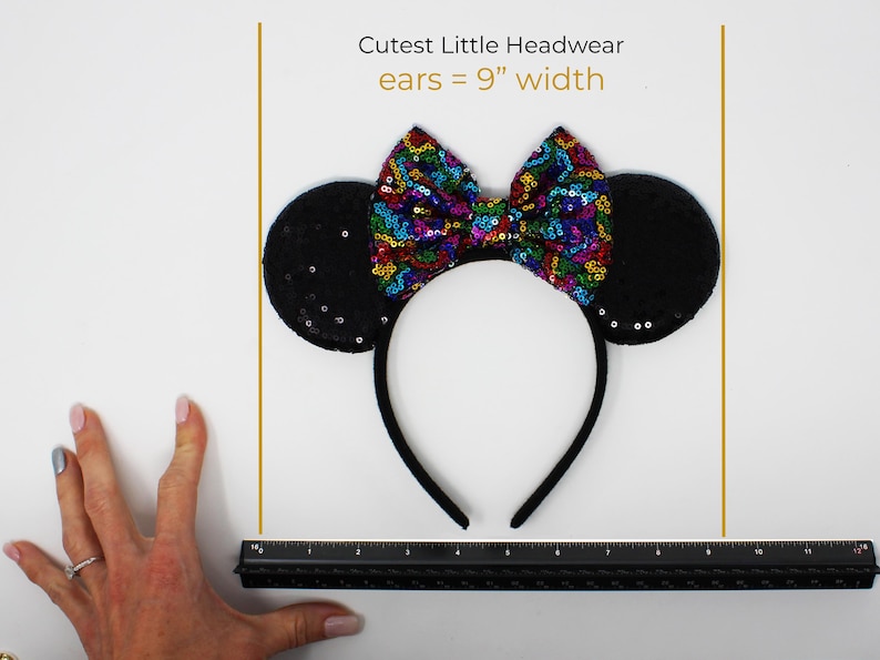 May include: A black headband featuring two round ears covered in black sequins and a central bow decorated with multicolored sequins. Text above the headband reads Cutest Little Headwear ears = 9" width, with a black ruler positioned below.