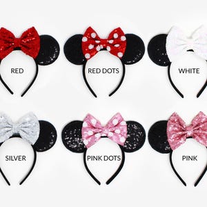 May include: Six headbands with black sequined ears and various bows: red, red with white dots, white, silver, pink with white dots, and pink. Each headband is labeled with its color name: RED, RED DOTS, WHITE, SILVER, PINK DOTS, and PINK.