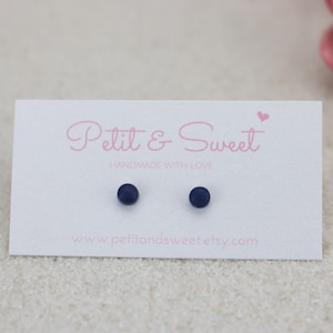 May include: A pair of small, round, dark blue stud earrings on a white card with the text "Petit & Sweet - Handmade with Love - www.petitandsweet.etsy.com".