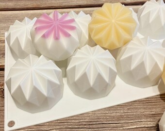 May include: A white silicone mold with eight star-shaped cavities. The mold is filled with white, yellow, and pink soap.