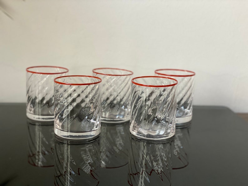May include: Set of six clear glass tumblers with a red rim and a swirl pattern.