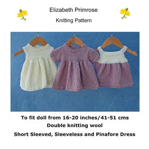 May include: Three knitted doll dresses in white, purple, and pink. The dresses are short-sleeved, sleeveless, and pinafore styles. The dresses are designed to fit dolls from 16-20 inches (41-51 cm).