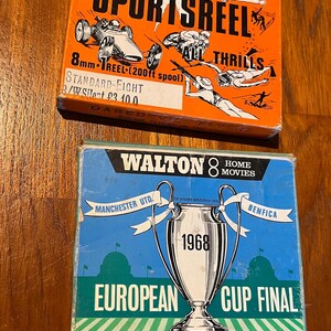 May include: Two vintage 8mm film reels. The top reel is orange and features the text "Heritage Films" and "Sportsreel" in black. The bottom reel is blue and features the text "Walton 8 Home Movies" and "European Cup Final" in white. The bottom reel also features a black and white image of a soccer trophy.