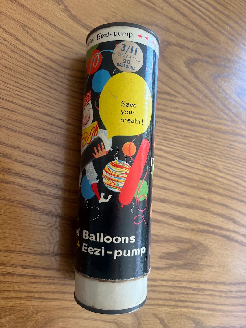 Puede incluir: Un recipiente cil&iacute;ndrico vintage para globos "Eezi-pump". El contenedor negro presenta ilustraciones de globos coloridos, un payaso y el texto "Save your breath!". Una etiqueta indica que contiene 20 globos.