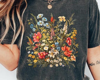 May include: A dark gray t-shirt with a floral print featuring a variety of colorful flowers, including red, pink, yellow, blue, and white.
