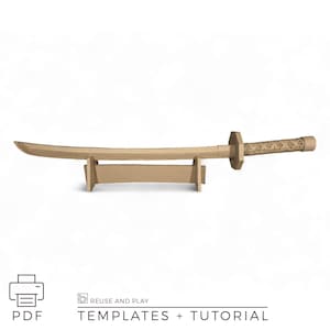 May include: A cardboard katana sword with a stand. The sword is light brown and has a curved blade, a rectangular handguard, and a textured handle. The stand is also light brown. The image includes the text "PDF" and "TEMPLATES + TUTORIAL".