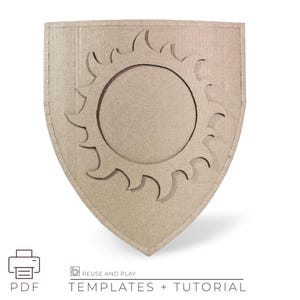May include: A tan cardboard shield featuring a cut-out sun design. The shield has a rounded base and a pointed top. The sun design comprises a central circle with surrounding pointed rays. The image also includes the words "PDF" and "TEMPLATES + TUTORIAL".