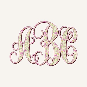 May include: A floral monogram design featuring the letters ABC in a flowing script. The letters are filled with a pattern of pink flowers, yellow accents, and green leaves, outlined in a dark brown colour, set against a light background.
