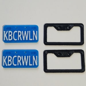 Puede incluir: Dos placas de matr&iacute;cula de pl&aacute;stico azul con el texto "KBCRWLN" en letras blancas. Dos marcos de matr&iacute;cula de pl&aacute;stico negro.